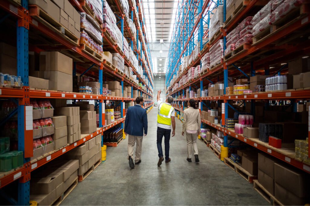 Workers walking through a US 3PL warehouse with stocked inventory shelves